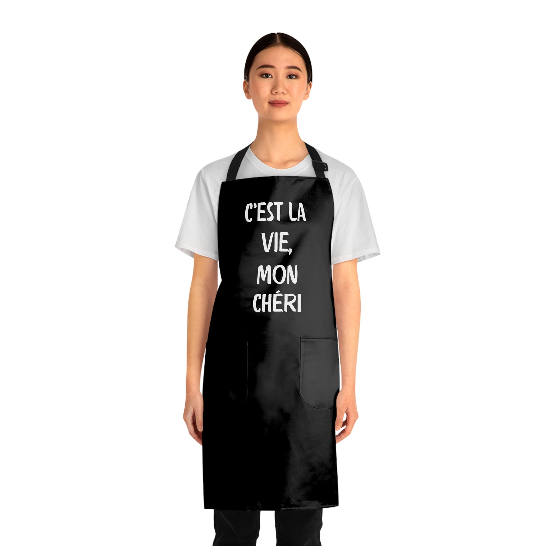 front view of a woman wearing a black grilling apron with black straps with says "c'est la vie, mon chéri"