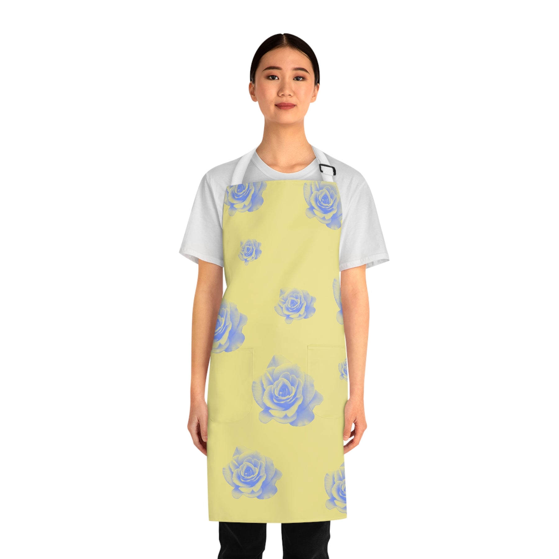 front view of girl wearing a grilling apron with a yellow and blue rose pattern on it, 2 pockets and white straps