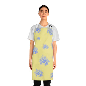 front view of girl wearing a grilling apron with a yellow and blue rose pattern on it, 2 pockets and white straps