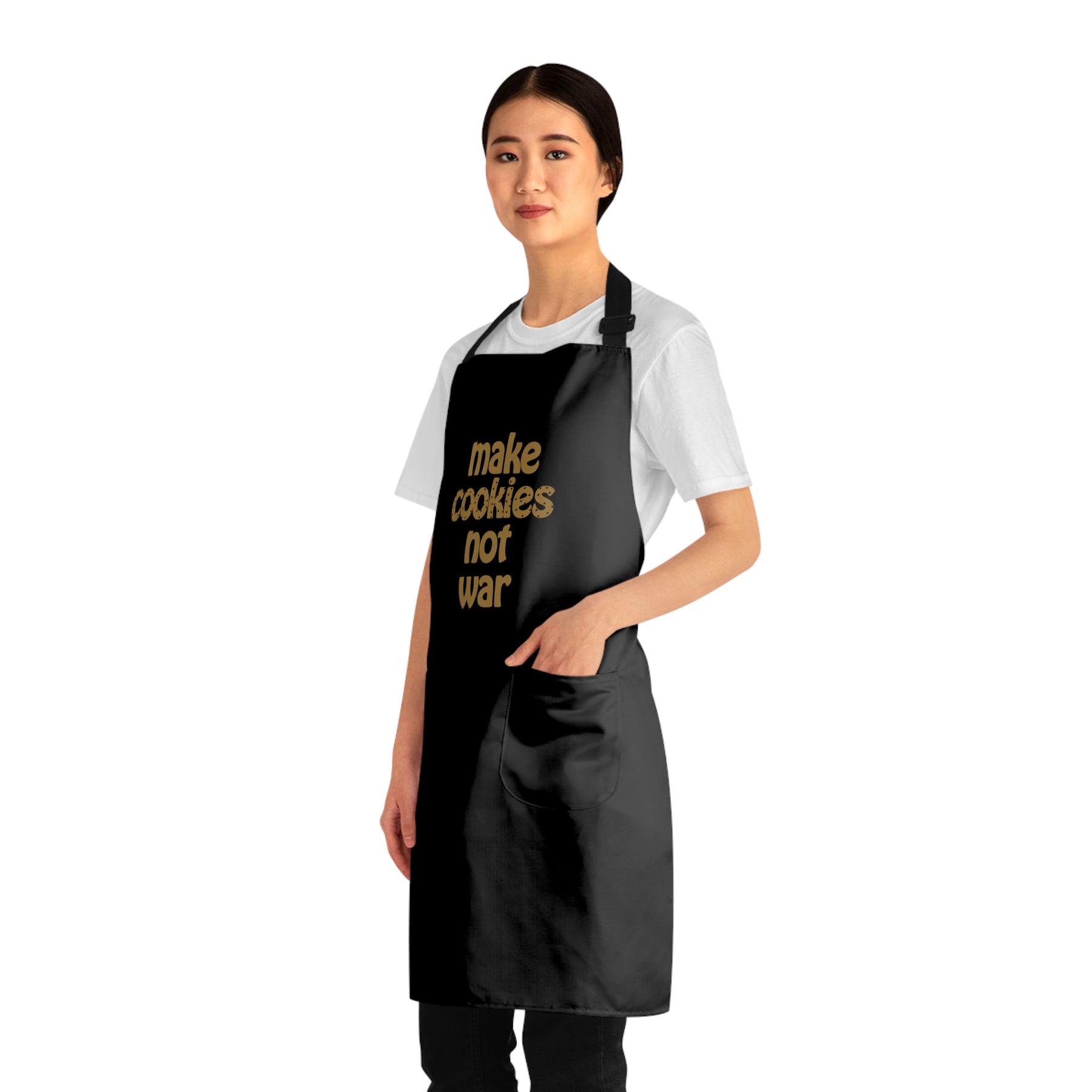 side view of a girl wearing a black apron that says "make cookies not war" with her hand in one of the pockets 