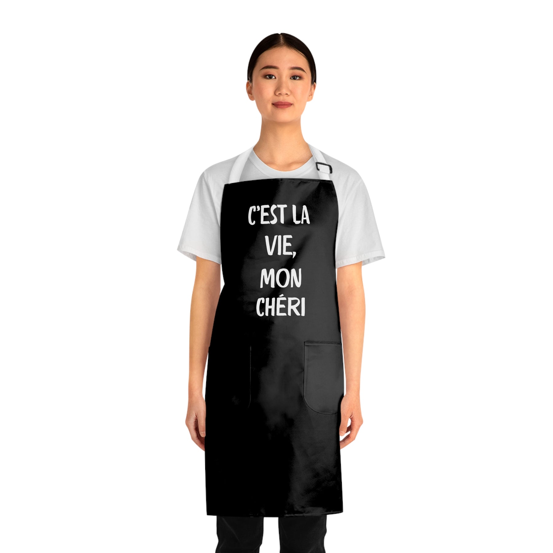 front view of a woman wearing a black grilling apron with white straps with says "c'est la vie, mon chéri"