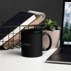 Side view of a black mug on a desk that says "c'est la vie, mon chéri"