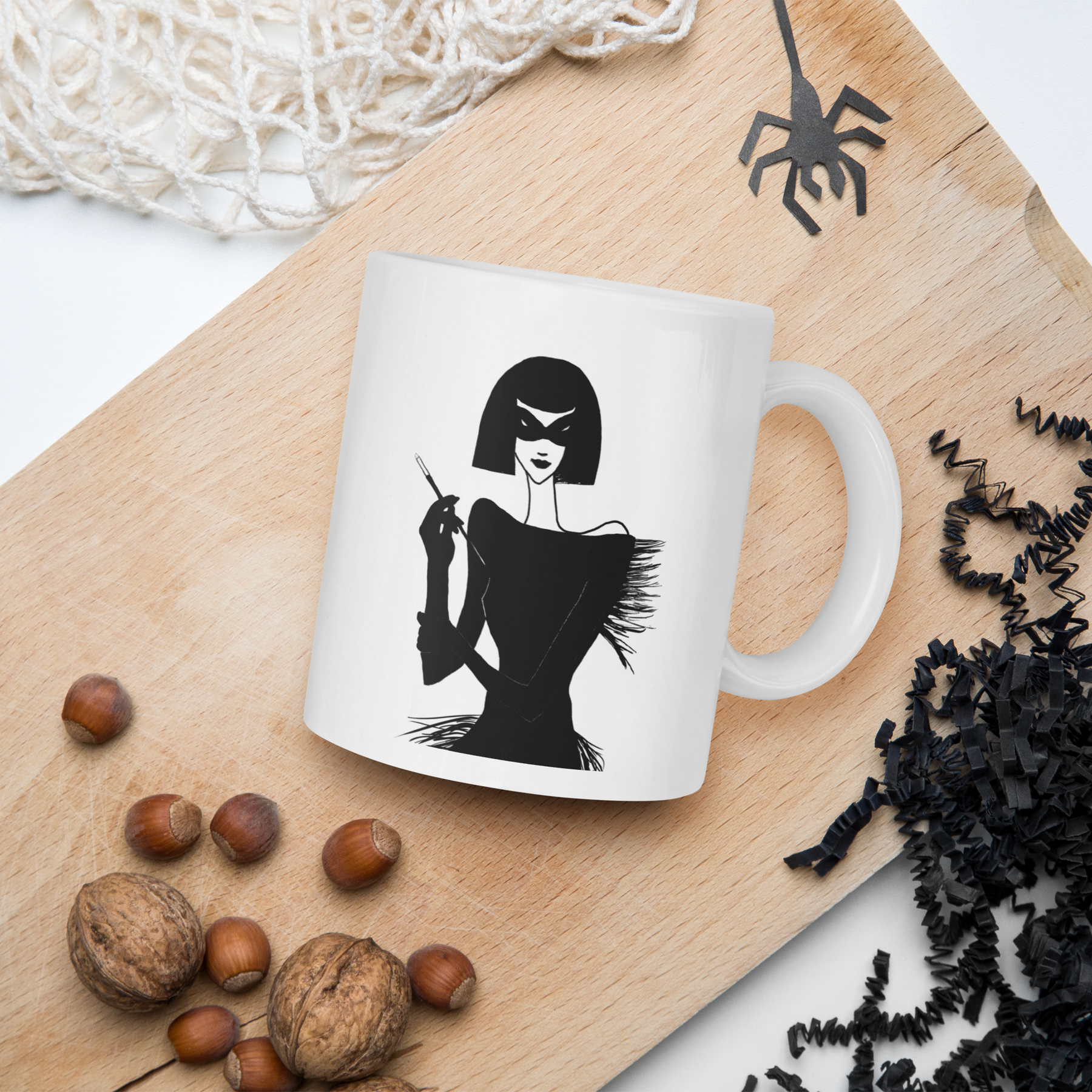 interior view of a cutting board with a coffee mug with an ink drawing of a 1920's woman in a mask and holding a long cigarette